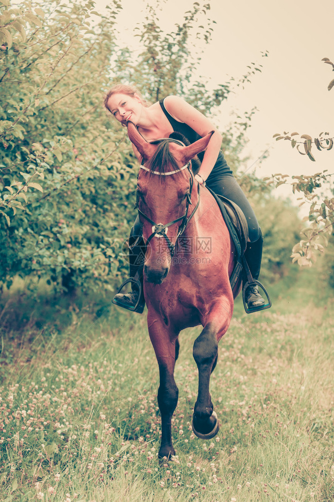 年轻女人坐在马背上靠着它拥抱和倾斜出家门的年轻女人图片