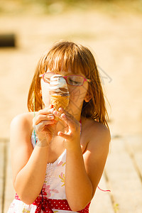 沙滩上吃冰淇淋沙滩上吃冰淇淋的托德勒女孩图片