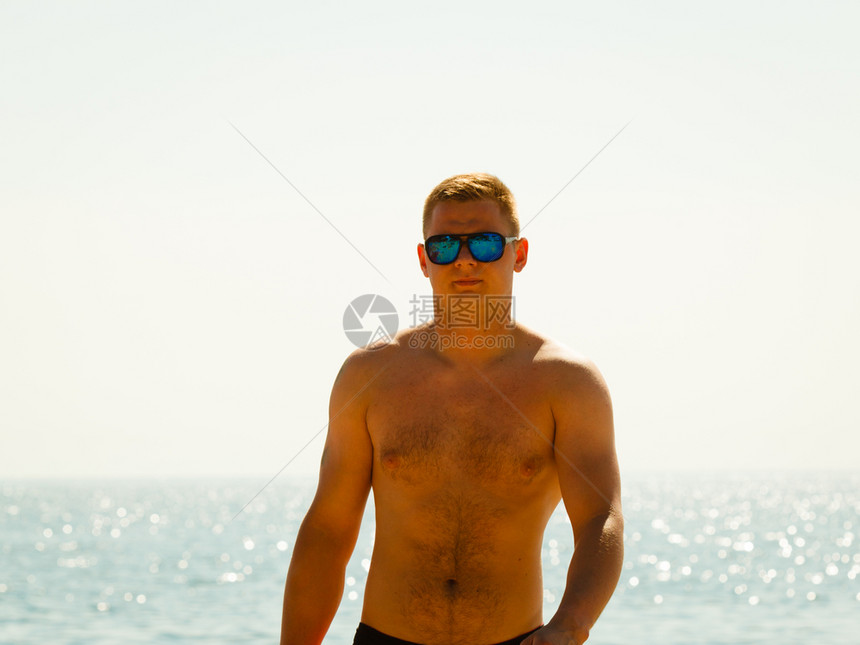 青年运动男子在海边滩度假图片