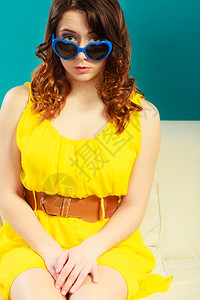 穿着蓝色心型墨镜的紧身女孩长卷头发穿着蓝色心型太阳镜的柔礼服图片