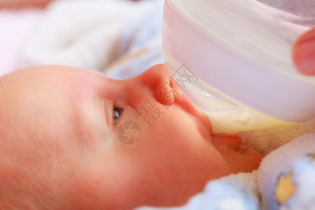 婴儿护理和喂养概念小新生儿从瓶中喝牛奶的婴儿小新生从瓶中喝饮料的婴儿小新生背景图片