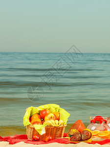 夏季时期的放松概念海边的红毯子上有水果的彩礼篮子背景图片