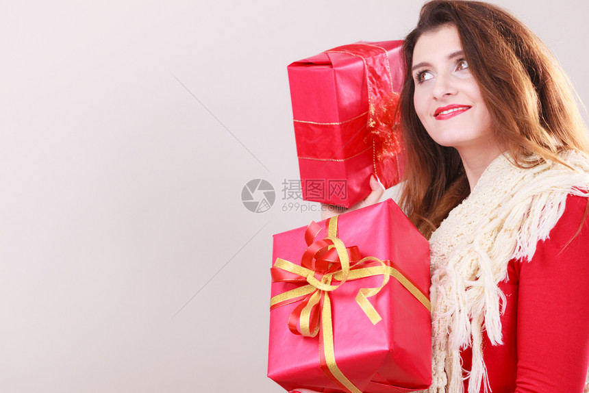 身着红色礼服温暖的羊毛披肩年轻女子拿着两个带丝的礼物盒圣诞节庆祝活动的概念妇女拿着红色圣诞礼物盒图片