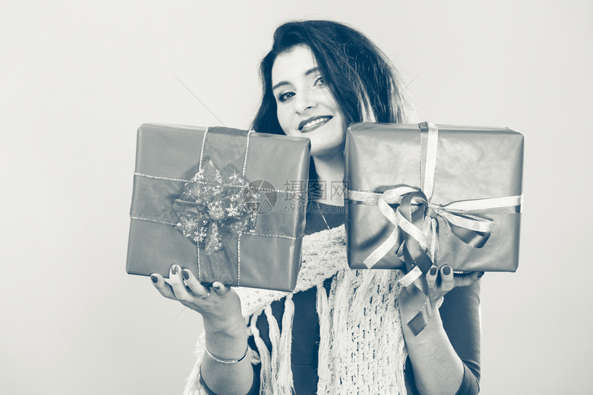持有两个带丝的礼物盒年轻女圣诞节庆祝概念女持有红圣诞礼物盒图片