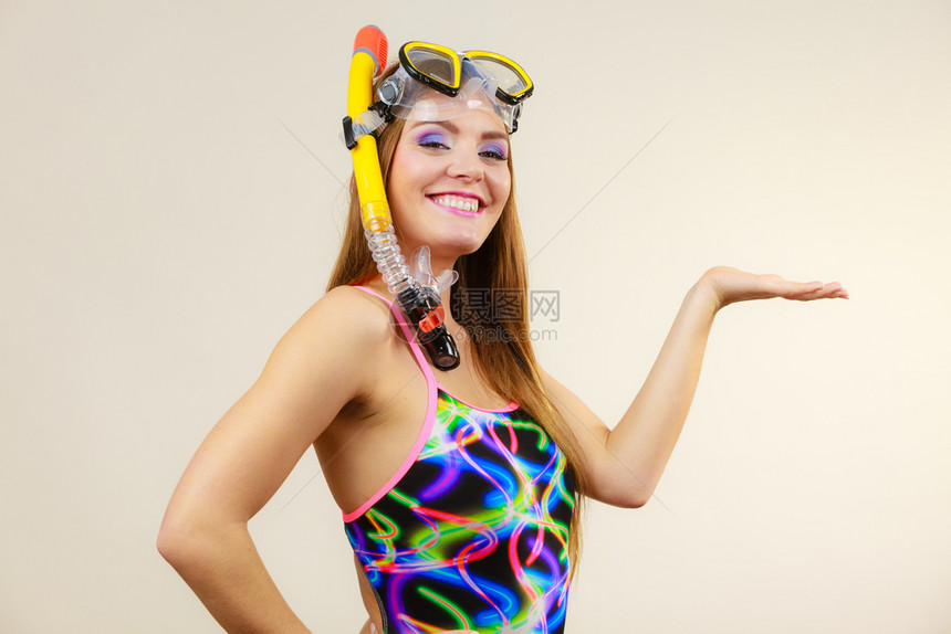 穿着泳衣有上下潜面罩手持开放产品复制空间的穿泳衣妇女在灰色微笑女孩梦想着积极的暑假图片