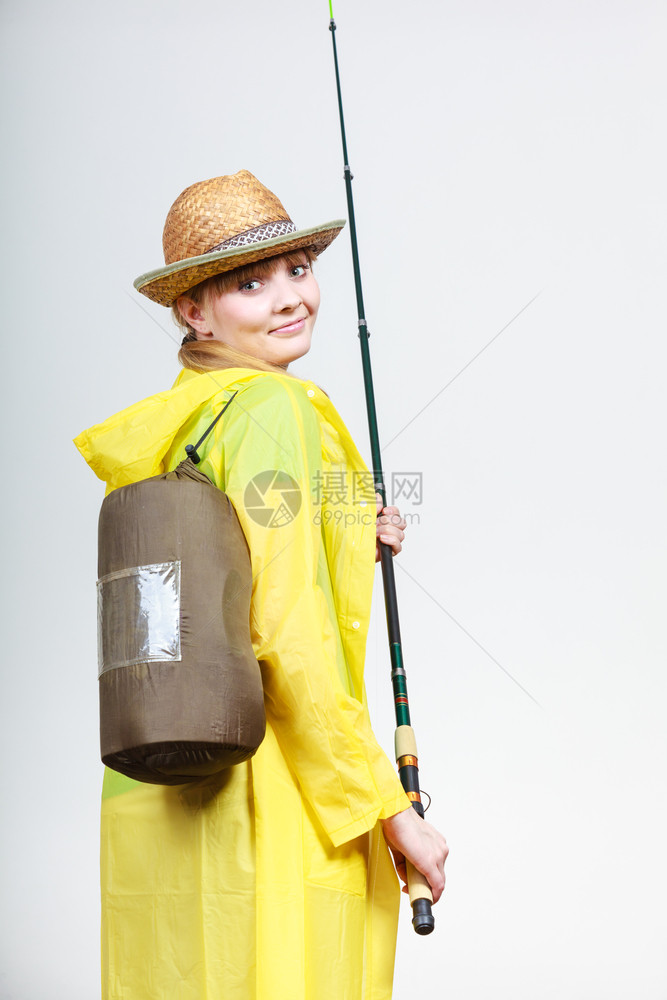 穿雨衣和背包的手持鱼棒妇女准备冒险图片