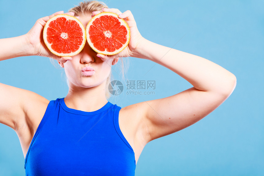 将两半的葡萄果柑橘握在手中遮住眼睛健康饮食品节假日快乐的概念图片