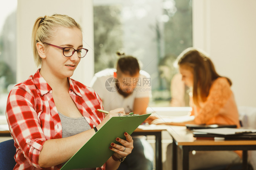 教育高中团队合作和人的概念笔记本坐在学生面前的女在课堂上的同班学图片