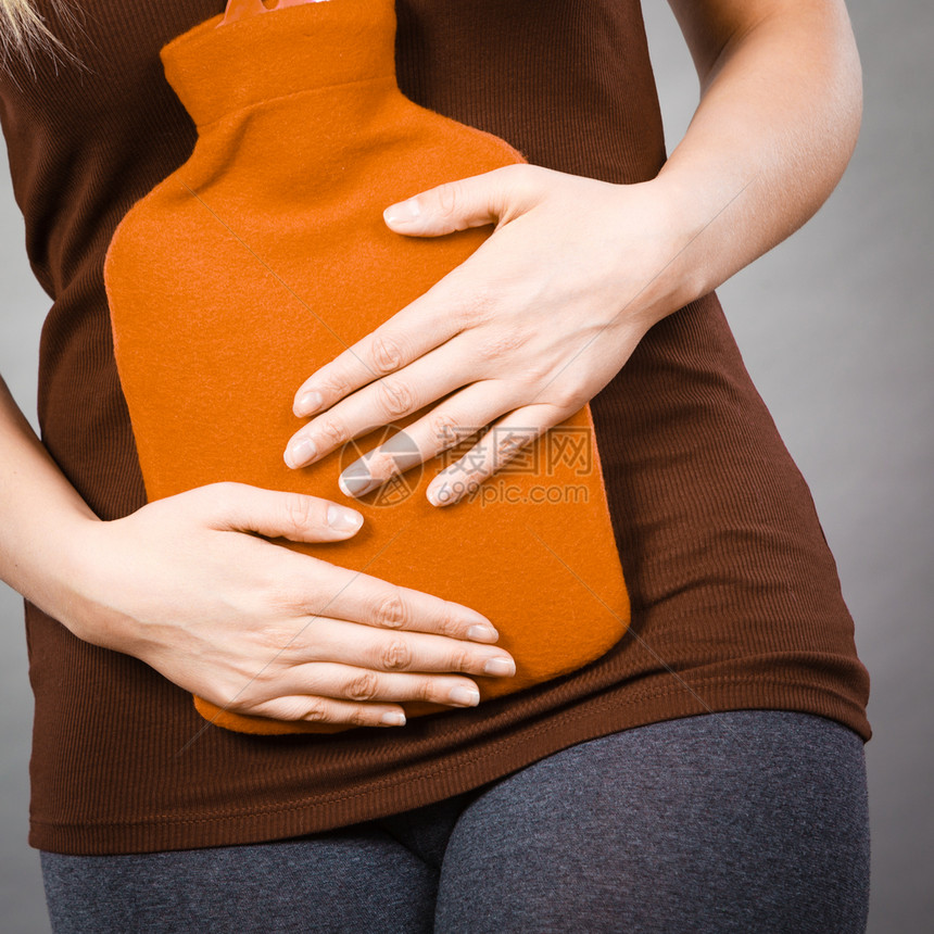 女腹部疼痛有热红水瓶腹部有热红水瓶卫生保健止痛的治疗概念胃痛的女孩有热水瓶图片