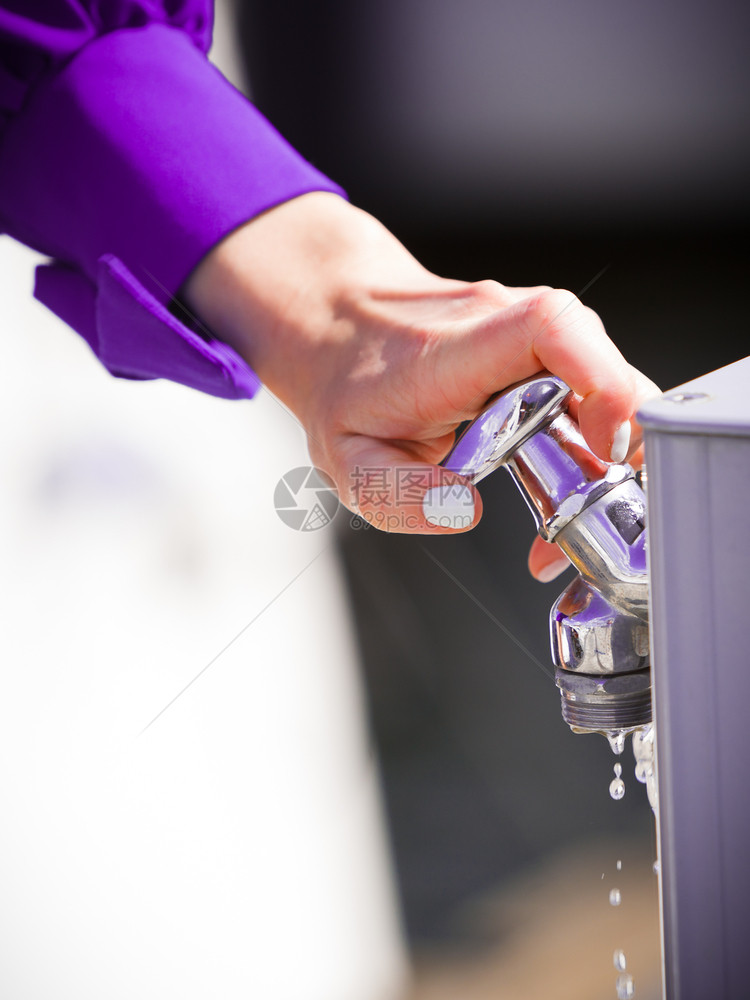 妇女用水分配器在户外洗手卫生概念图片