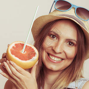 穿着草帽和太阳镜的快乐女游客他们持有葡萄果柑橘水健康饮食品暑假概念图片