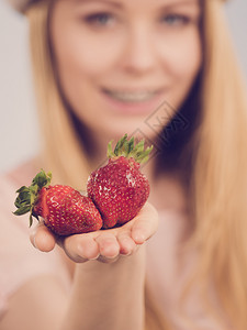 年轻女展示新鲜草莓水果健康饮食粉红色形象女孩展示新鲜草莓图片