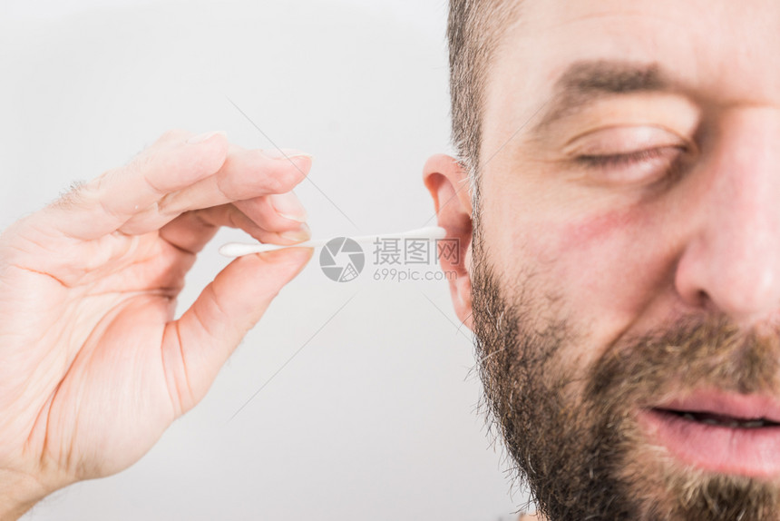 准备用Q棉巾擦耳朵的人卫生必需品概念将蜡从耳朵上除去使用棉巾擦耳朵的人将蜡从上除去图片