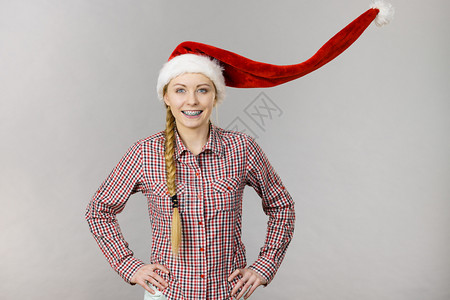 戴风吹圣诞老人帮手帽子的快乐妇女戴圣诞老人帮手帽子的快乐妇女图片