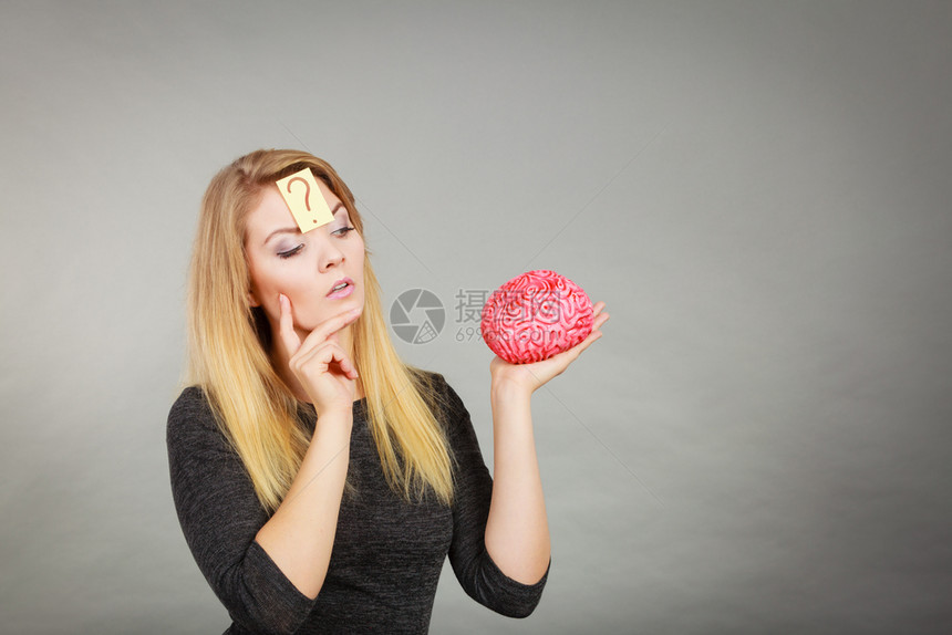 关闭有吸引力的脑部有疑问假大的女思考和持有假大脑的女形象图片