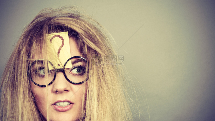 身着书呆子眼镜的疯女人在紧张思考前额有问题标记和头发乱之后精疲力尽图片