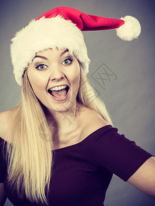 戴圣诞老人帮手帽子的快乐妇女图片
