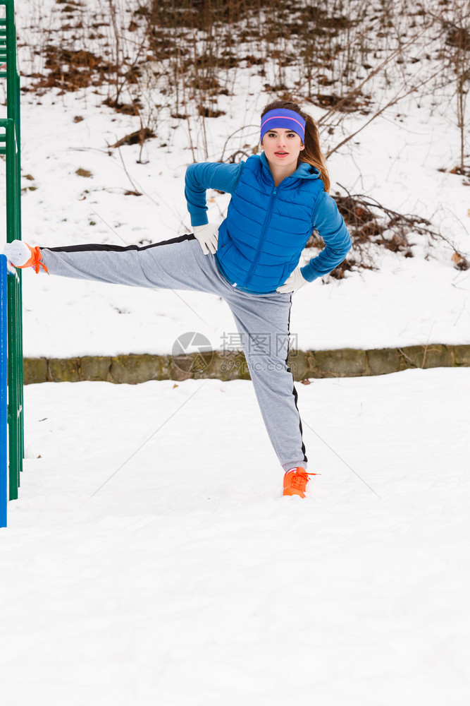 参加户外体育锻炼运动装饰思想参加温暖运动服训练的妇女冬季在户外伸腿锻炼穿着运动服的妇女冬季在户外锻炼参加运动服的妇女冬季在户外锻图片