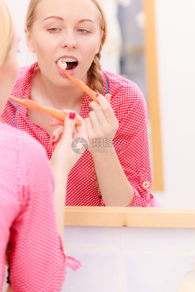 洗刷牙的女人手间里有牙刷的女孩看着镜子口腔卫生洗手间里有刷牙的女人图片