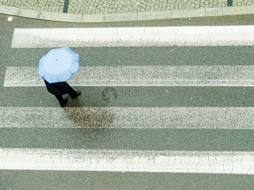 雨天时在城市街上行走的人拿着雨伞图片