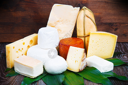 混合干酪和木板上含油叶子和坚果的混合干酪高清图片