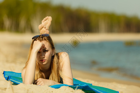 在比基尼日光浴和沙滩上休息的妇女背景图片