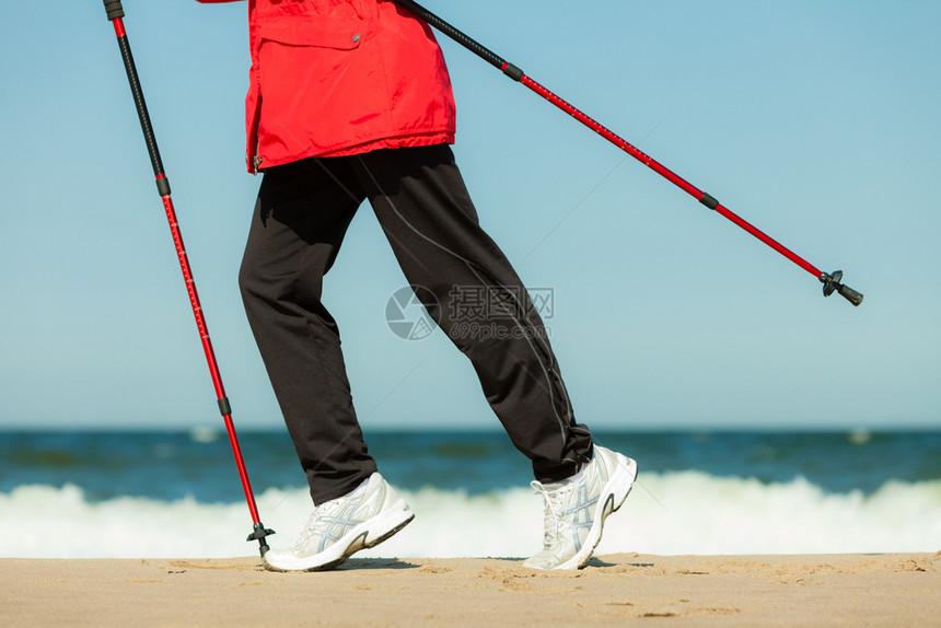 北欧步行女在海滩上徒步远足积极健康的生活方式图片