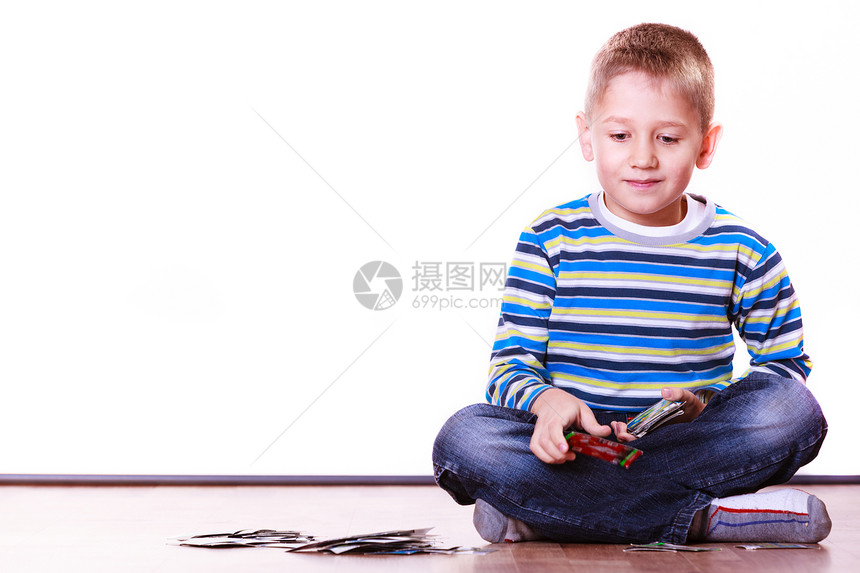 小男孩坐在地板上玩收集卡片图片