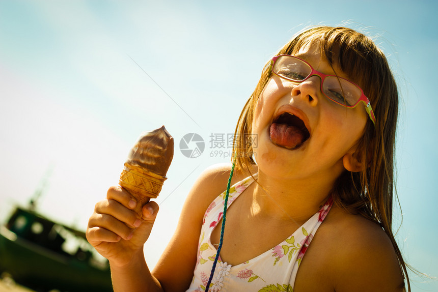 沙滩上吃冰淇淋沙滩上吃冰淇淋的托德勒女孩图片