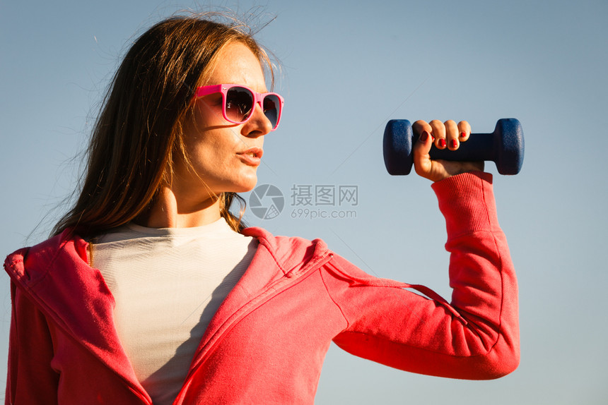 妇女与哑铃一起在户外运动海边场穿服的健身女孩与哑铃一起在户外运动的妇女图片