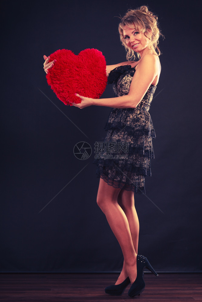 金发女子中年优雅的晚礼服穿着红色的心爱标志片工作室拍摄在黑色情人节快乐概念图片
