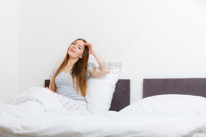 休息睡眠梦想舒适的概念女孩在床上打哈年轻女士早上醒来后在睡觉女孩床上打哈图片