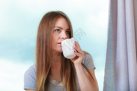 清晨女孩坐在阳台喝咖啡图片