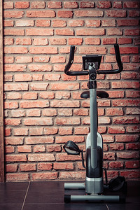 在健身中心用墙壁背景的固定训练单车在健身中心进行固定训练习图片