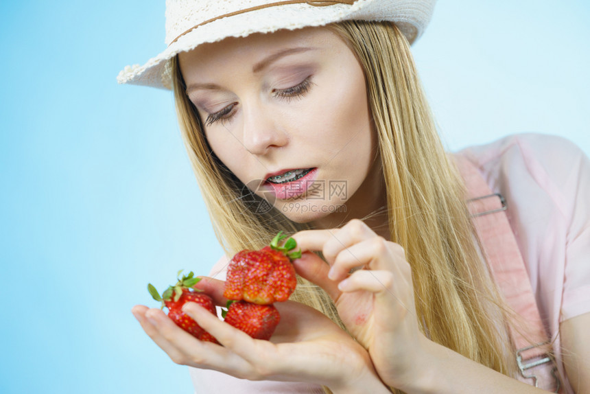 年轻妇女食用新鲜草莓水果健康饮食新鲜草莓和图片