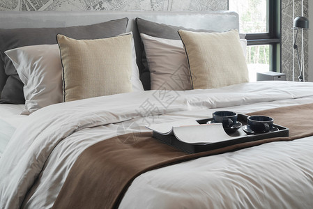 彩色灯板书和床上两杯咖啡带有经典彩色枕头背景