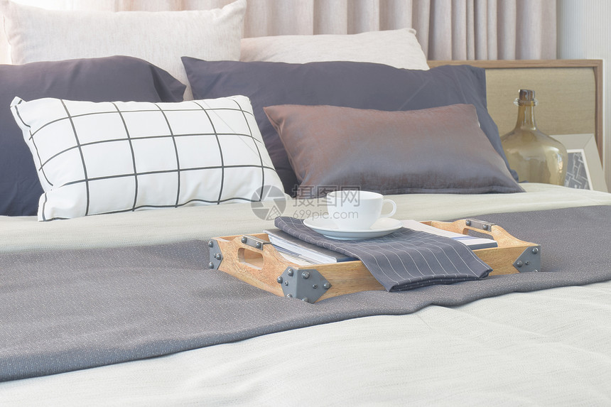 在现代古典风格室内卧的床上用木制托盘装在床上的咖啡杯图片