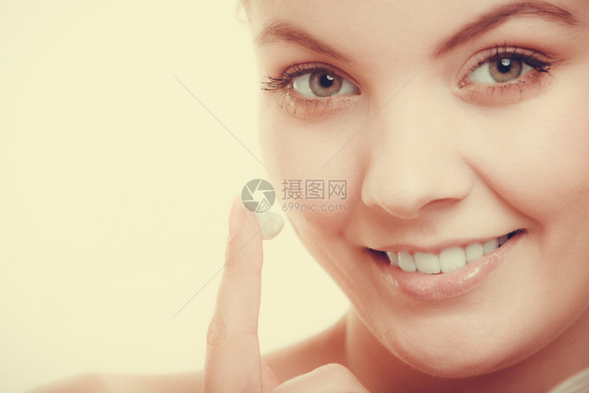 美容治疗女在面部演播室使用湿润奶油护肤产品拍摄的过滤照片女在皮肤上涂奶油图片