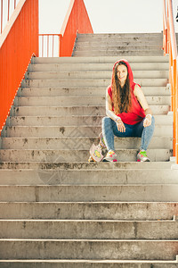 酷酷的长板运动员坐在城市的楼梯上图片