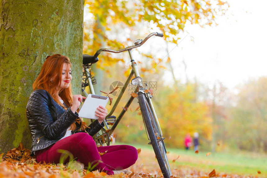 大自然户外概念在树下笑的女孩坐着享受秋天的气图片