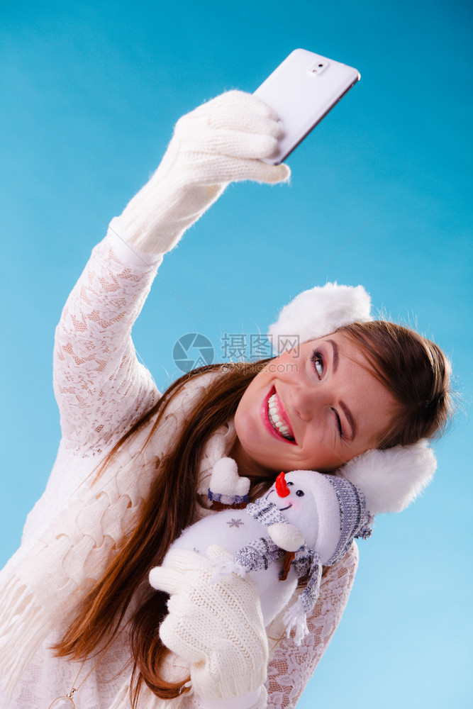 穿着耳毛和白色衣的迷人女孩穿着蓝色工作室穿着蓝色冬季时装穿着雪人小女拍自图片