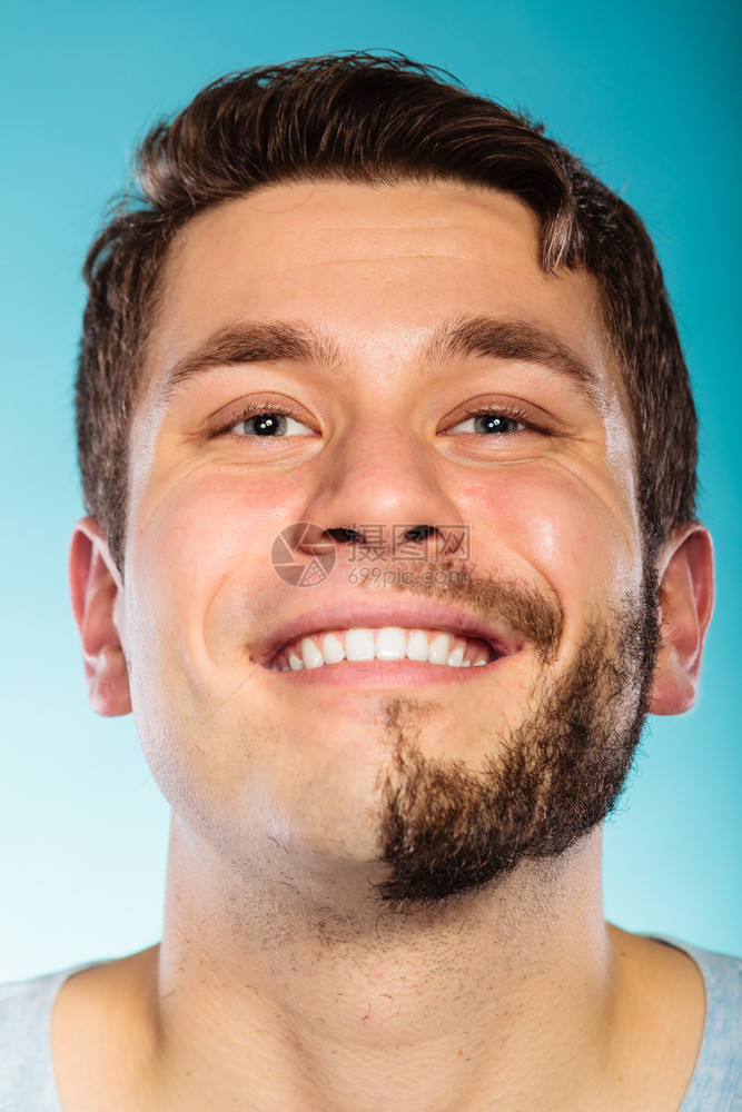 面部胡子毛半剃的快乐男人肖像蓝色笑脸帅哥皮肤护理和卫生脸部胡子半剃的快乐男人图片