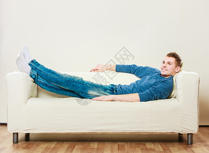 在家休闲概念英俊的年轻人在沙发上休息躺在床做梦图片