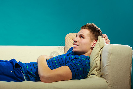 年轻男人在沙发上放松年轻快乐的男孩躺在床上懒图片