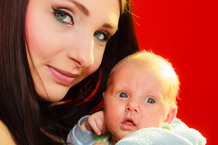 家庭母亲概念抱小新生儿的母亲红色背景母亲抱小新生儿图片