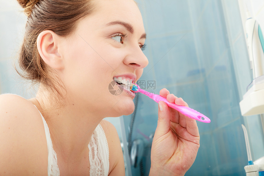 洗刷牙的年轻女子洗手间里有牙刷的女孩口腔卫生洗刷牙的女人图片