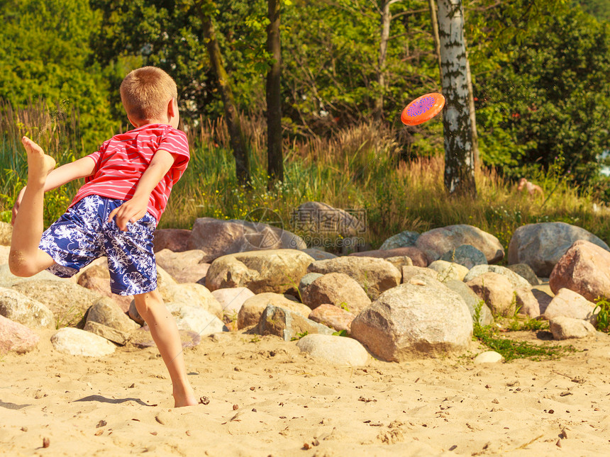 海滩上小男孩在开心的玩飞盘图片