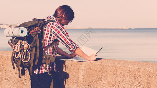 探险旅游积极生活方式青年长发男子践踏背心被海边践踏背景图片