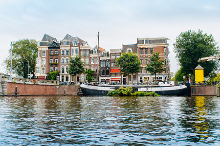 普林森格拉希特2017年9月5日荷兰阿姆斯特丹在荷兰阿姆斯特丹尔河静水中的树木和房屋反射背景
