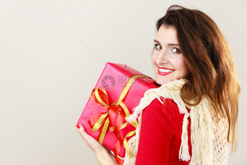 穿着灰色红盒礼物的漂亮迷人拉丁女生日纪念的圣诞节概图片